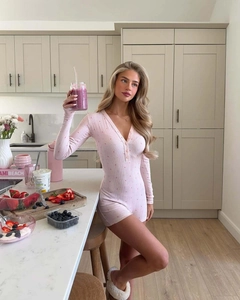 Dettaglio della tutina rosa floreale in maglia con scollo a V e maniche lunghe
