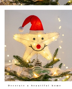 Glow star tree topper with smiley face and red hat on a festive Christmas tree