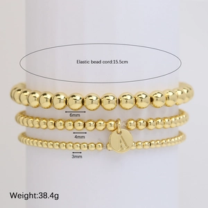 Set of three golden beaded elastic bracelets with letter A pendant in 3mm 4mm 6mm sizes