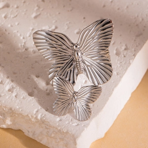 Macro shot of silver butterfly rings featuring detailed radial engraving on metal wings