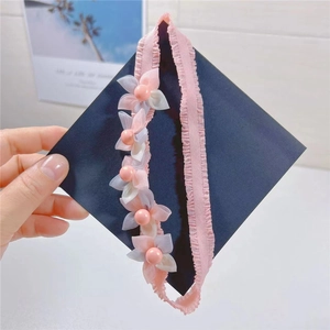 Detail of pink lace headband featuring five handmade flowers with pearl bead centers