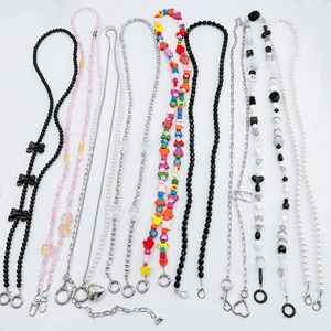Detailed overhead view of assorted beaded crossbody phone chains with charms and metal clips