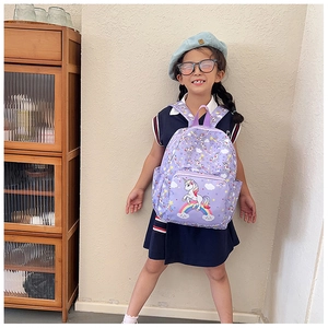 Close-up of cute purple unicorn backpack with rainbow prints on durable canvas fabric