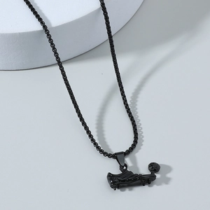 Detail of a black electroplated football boot pendant on a round box chain necklace