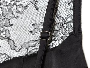 Detail of adjustable straps and lace stitching on a black silk satin camisole top