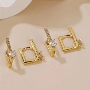 Détail macro de boucles d'oreilles dorées avec oxydes de zirconium et pavage latéral