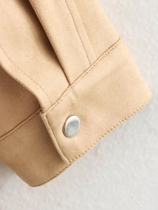 Detailed close-up of camel suede coat cuff with premium silver matte metal snap button