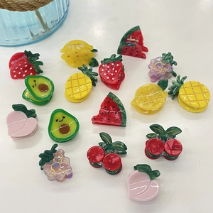 Vibrant acetate fruit hair clips including strawberry and cherry designs on white background