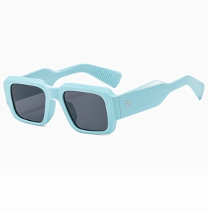 Detail view of sky blue thick square frame sunglasses with dark UV protection lenses