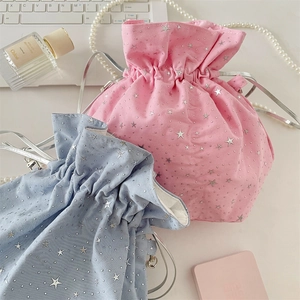 Detail of pink and blue drawstring pouches with silver star patterns and cord closure