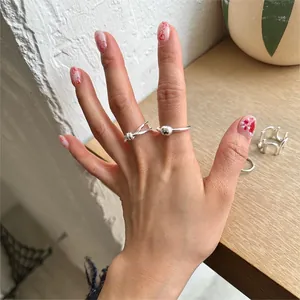 Detailed shot of stacked S925 sterling silver knot rings on hand for minimalist styling