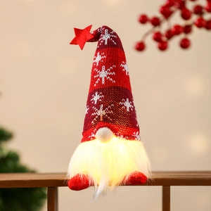 Close-up of a glowing Christmas gnome with red star hat and warm LED lighted beard
