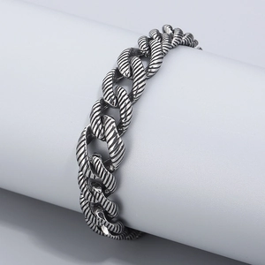 Detailed view of silver Cuban chain bracelet with spiral textures and OT buckle clasp