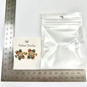 Size comparison of snowflake earrings with rhinestones and pearls against a metal ruler