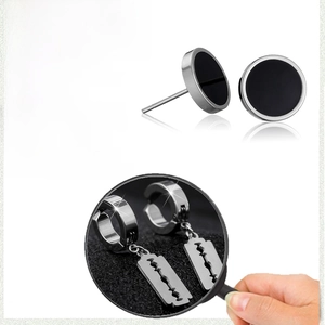Macro detail of black stainless steel barbell stud with a blade-shaped pendant earring