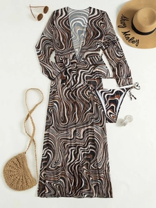 Flat lay of a three-piece striped bikini set with a long-sleeved cover-up and beach accessories