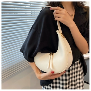 Detail of white half-moon underarm bag with sleek PU leather and golden zipper pulls
