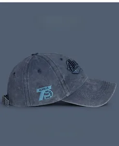 Detail of 3D embroidery and adjustable metal buckle on navy washed cotton baseball cap