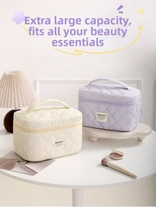 Detailed view of quilted makeup bags in beige and lavender with elegant top handles