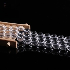 Macro view of transparent round beads in parallel rows on a black reflective surface