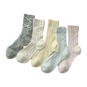 Five pairs of rib-knit crew socks with white bows in pastel pink, green, grey, and beige