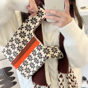 Minimalist knit tote bag with brown snowflake pattern and orange stripe accents