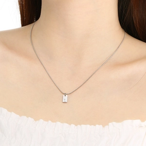 Detail van de minimalistische zilveren roestvrijstalen ketting met letter L hanger