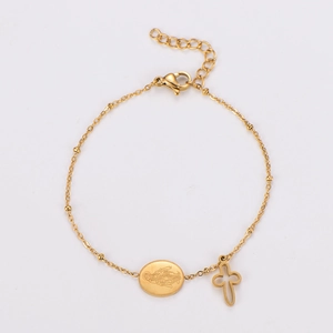 Detail of gold-plated stainless steel bracelet with oval icon and hollow cross charms