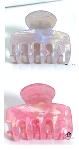 Primo piano di mollette per capelli in acetato marmorizzato lilla e rosa lucido