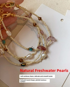 Macro shot of freshwater pearl layered bracelet with golden lobster clasp and colorful stones