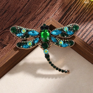 Vintage dragonfly brooch with green and blue crystals in a retro gold metal setting
