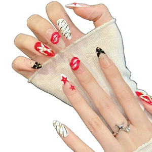 Amandel kunstnagels met rode 3D-lippen, zebrastrepen en gouden studs op modelhand