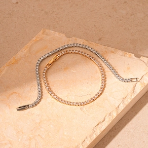 Bracelets tennis élégants en argent et or avec zircons carrés sur fond de pierre beige