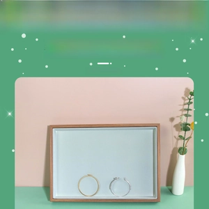 Detail of rosewood jewelry tray with light blue velvet lining and metal bracelets