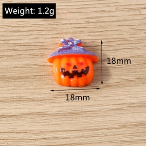 Detail view of 18mm resin Halloween pumpkin charm with purple bow on wooden background