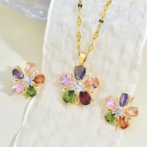 Exquisite gold floral jewelry set with colorful zircon stones on white fabric backdrop