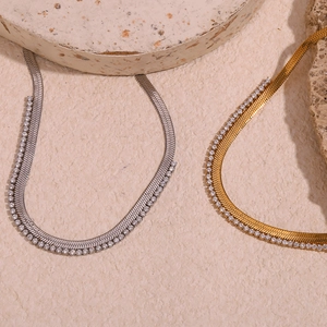 Detail of gold and silver herringbone chain necklace with micro-pave cubic zirconia