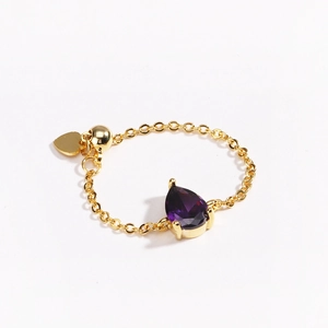 Détail d'une bague chaîne ajustable plaquée or 18k avec une gemme violette en poire