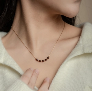Elegante collana placcata oro 18K con perline di granato rosso indossata da una modella