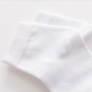 Close-up of white cotton socks showing knitted texture and elastic cuff detail