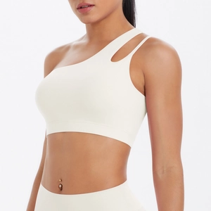 Detail of cream white yoga bra featuring asymmetric shoulder strap and cutout design