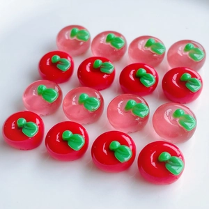 Macro shot of 3D resin apple charms for DIY crafts in red and translucent pink colors