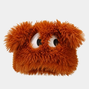 Detail of orange faux fur plush hat featuring large cartoon eyes and fluffy texture