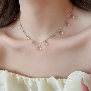 Gros plan d'un collier argenté avec pendentifs en perles de résine sur un mannequin