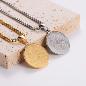 Gold and silver Saint Benedict Medal necklaces in polished stainless steel on stone