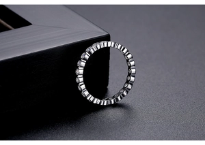 Macro detail of silver bezel-set cubic zirconia ring on professional matte dark background
