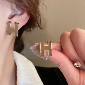 Vintage style H-letter stud earrings with gold finish and light brown enamel inlay