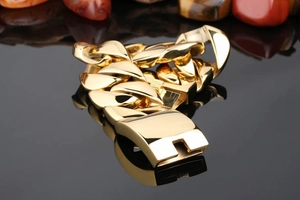Detailed close-up of heavy gold Cuban link bracelet featuring a secure locking clasp