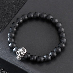 Detailed view of black matte 8mm beads and silver skull charm on a men's bracelet