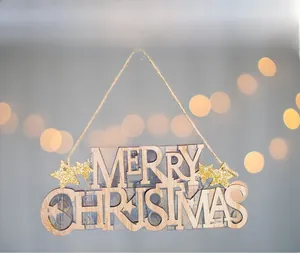 Close-up of wooden Merry Christmas sign with gold glitter stars and rustic hemp rope